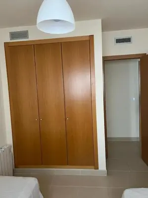 a bedroom with a large wooden cabinet in a room at Apartamento en Playa moncófar a tan solo 300 metros in Moncófar