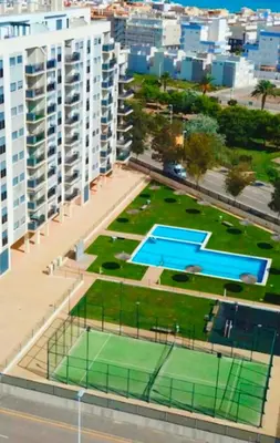 a large apartment building with a tennis court in front of it at Apartamento en Playa moncófar a tan solo 300 metros in Moncófar