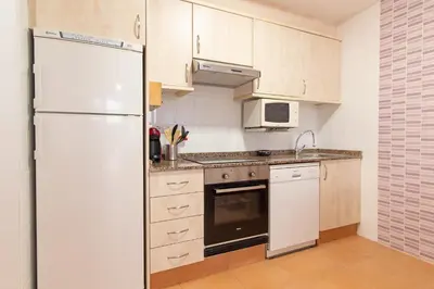 a kitchen with white cabinets and a refrigerator at Global Vacacional, Planta Baja con Piscina en Canet de Berenguer in Canet de Berenguer