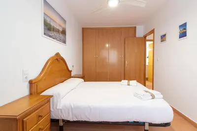 a bedroom with two beds and a wooden cabinet at Global Vacacional, Planta Baja con Piscina en Canet de Berenguer in Canet de Berenguer