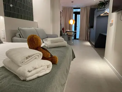 a teddy bear sitting on a bed with towels at Osito Hub - Pintor Nicolau in Valencia