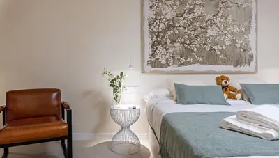 a bedroom with two beds and a chair and a teddy bear at Osito Hub - Pintor Nicolau in Valencia