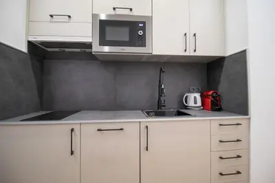 a kitchen with white cabinets and a microwave at BedTime Suites by Concept Flats in Valencia