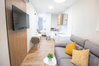 a living room with a couch and a kitchen at Suite Parque del Turia by Concept Flats in Valencia