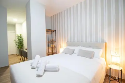 a bedroom with a white bed with towels on it at Suite Parque del Turia by Concept Flats in Valencia