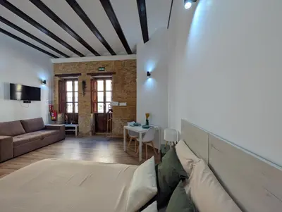 a living room with a couch and a tv at Las Arenas Suites 2 Playa in Valencia