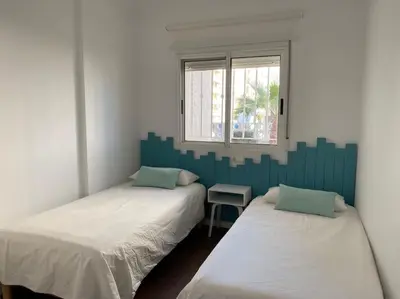 two twin beds in a room with a window at Acogedor apartamento en primera línea de playa in Canet de Berenguer
