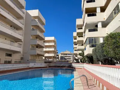 a swimming pool in front of some apartment buildings at Acogedor apartamento en primera línea de playa in Canet de Berenguer