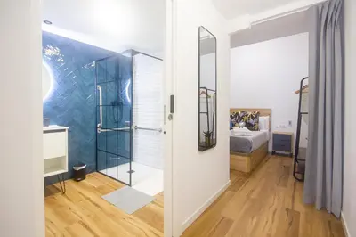 a room with a glass shower and a bedroom at Portobeach Valencia Suites in Valencia