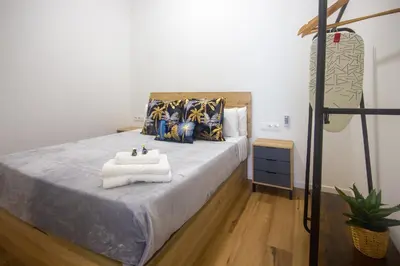 a bedroom with a large bed with a sink on it at Portobeach Valencia Suites in Valencia