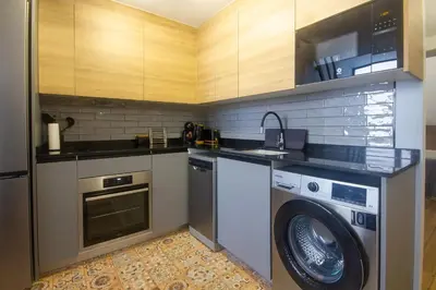 a kitchen with a washing machine and a washer at Portobeach Valencia Suites in Valencia