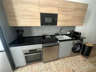 a kitchen with a sink and a washing machine at Portobeach Valencia Suites in Valencia