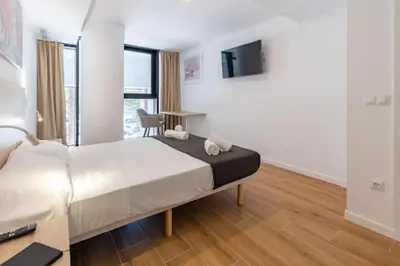 a bedroom with a bed and a desk and a tv at Duplex 6 pax 2 BTH, excelent area luxor in Valencia