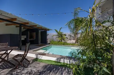 a swimming pool with a table and chairs next to a house at Calm House, a 10 min playa de la de Cullera in Llaurí