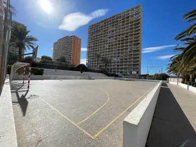an empty basketball court in a city with buildings at Bungalow on the beach 15 minutes from Valencia in Valencia