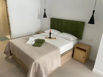 a bedroom with a large bed with a green headboard at Mar&Sol Flats by Vivo GC in Valencia