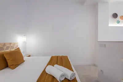 a white bedroom with a bed with towels on it at FLORIT FLATS - Quiet and Cozy Studios by the Joaquin Sorolla Station in Valencia
