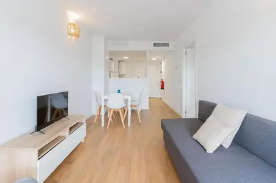 a living room with a blue couch and a table at Canet Seaview Gem: Pool & Beach Proximity in Canet de Berenguer