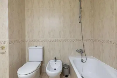 a bathroom with a toilet and a bath tub at ApartUP Patacona Infinity in Valencia