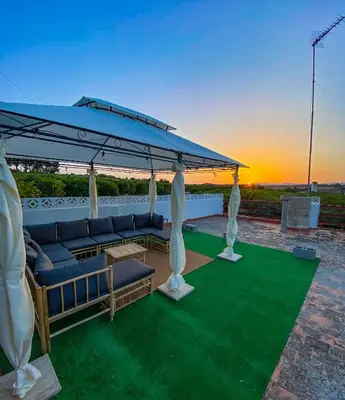 a patio with a blue umbrella and chairs and a table at Villa Caliqueña, casa de campo in Torrent