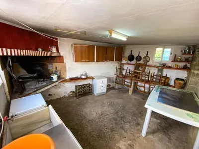 an old kitchen with a table and a fireplace at Villa Caliqueña, casa de campo in Torrent