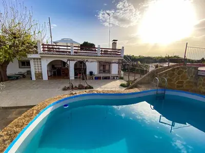 a house with a swimming pool in front of a house at Villa Caliqueña, casa de campo in Torrent