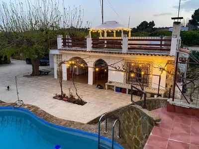 a building with a swimming pool in front of it at Villa Caliqueña, casa de campo in Torrent