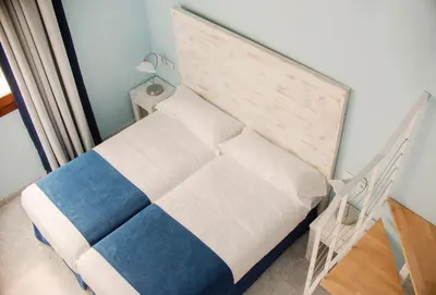 a small bedroom with a bed with a blue and white at Ad Hoc Carmen in Valencia