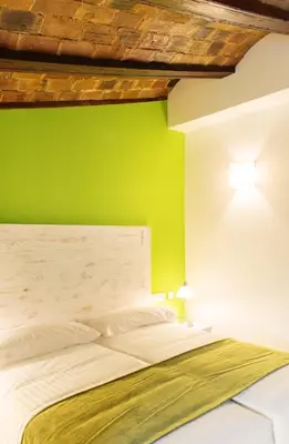 a bedroom with a white bed with a green wall at Ad Hoc Carmen in Valencia