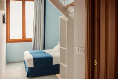 a small bedroom with a bed and a window at Ad Hoc Carmen in Valencia