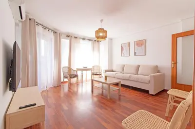 a living room with a couch and a table at Global Vacacional, Apartamento cerca de la playa en Puerto Sagunto in Puerto de Sagunto