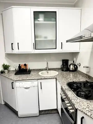 a kitchen with white cabinets and a sink at Casa Únic - Modern Central Home in Ruzafa in Valencia