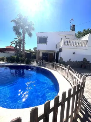 a swimming pool in front of a white house at Villa en Valencia, piscina privada y metro 500m in La Eliana