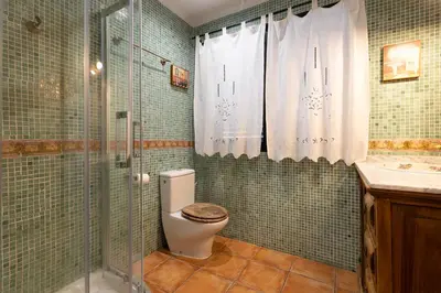 a bathroom with a toilet and a glass shower at Villa en Valencia, piscina privada y metro 500m in La Eliana