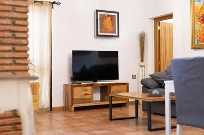 a living room with a flat screen tv on a table at Villa en Valencia, piscina privada y metro 500m in La Eliana