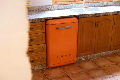 an orange dishwasher in a kitchen next to a sink at Villa en Valencia, piscina privada y metro 500m in La Eliana
