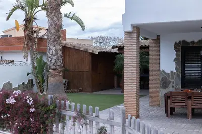 a house with a white fence and a palm tree at Villa en Valencia, piscina privada y metro 500m in La Eliana