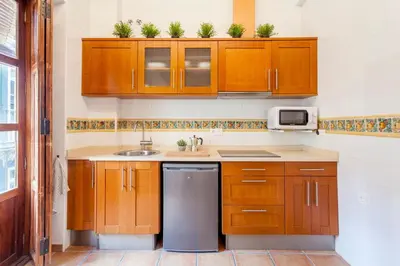 a kitchen with wooden cabinets and a sink at Sunny Modern Flat by Mercado Central in Valencia