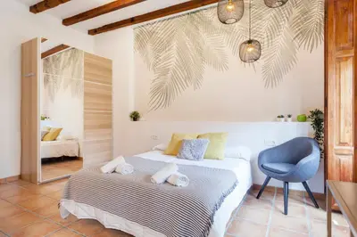 a bedroom with a bed and a blue chair at Sunny Modern Flat by Mercado Central in Valencia