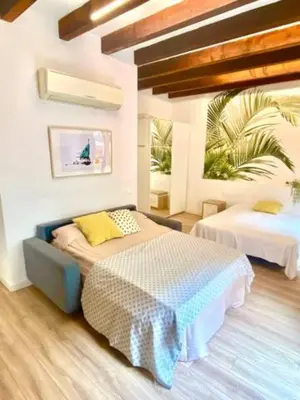 a bedroom with two beds and a palm tree at Sunny Modern Flat by Mercado Central in Valencia