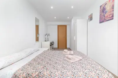 a bedroom with a bed with a pair of slippers on it at Barraca Breeze in Valencia