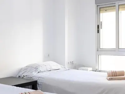 two beds in a white room with a window at Barraca Breeze in Valencia