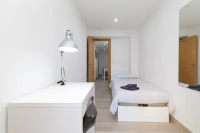 a white room with two beds and a lamp at Barraca Breeze in Valencia