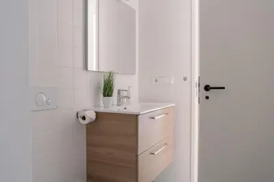 a white bathroom with a sink and a shower at Coliving La Alfareria in Valencia