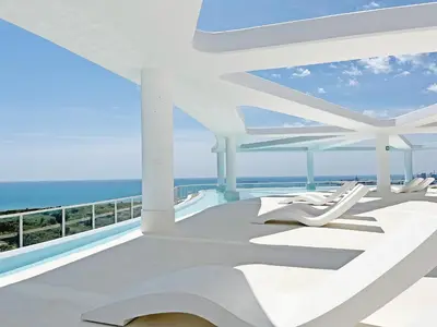 a balcony with white chairs and the ocean at Global Vacacional, Nuevo apartamento con piscina privada y terraza con vistas al mar in Canet de Berenguer