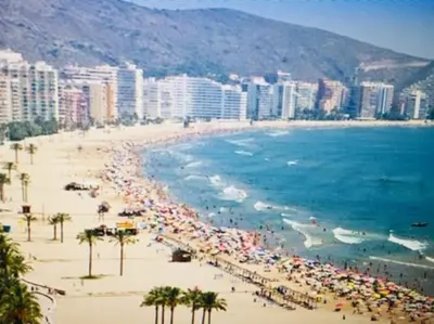 a beach with a lot of umbrellas and the ocean at Piso a 3 minutos de la playa!! 6 personas in Cullera