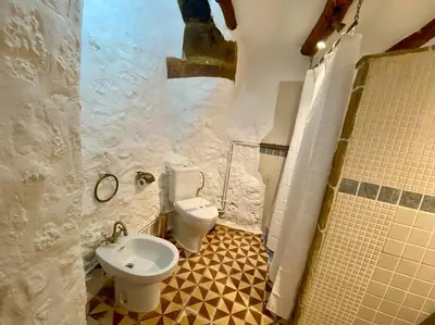 a bathroom with a toilet and a sink at Apartamentos Ca Federo, Casa la Tía Elena in Losa del Obispo