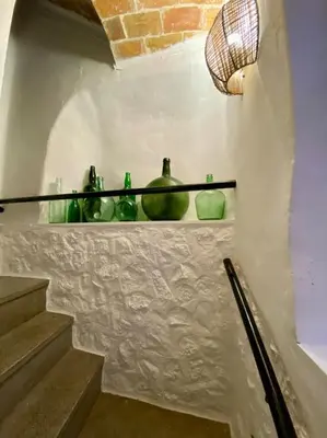 a staircase with green glass vases on a shelf at Apartamentos Ca Federo, Casa la Tía Elena in Losa del Obispo