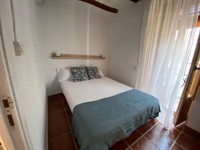 a small bed in a small room with a window at Apartamentos Ca Federo, Casa la Tía Elena in Losa del Obispo