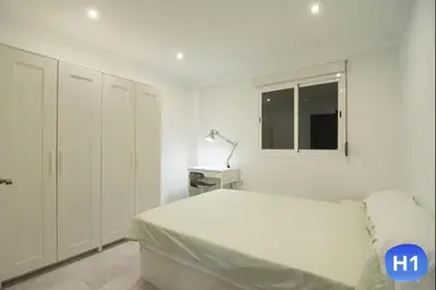 a white bedroom with a bed and a window at Despuig Delight in Valencia